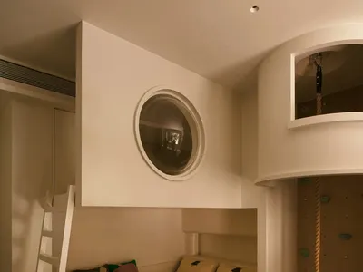 Modern bedroom with a bunk bed featuring a ladder and a climbing wall