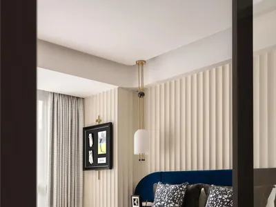 A modern bedroom featuring a fabric upholstered bed and geometric patterned rug.
