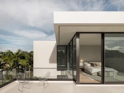 A modern, minimalist bedroom featuring glass walls, a wooden floor, and concrete accents.