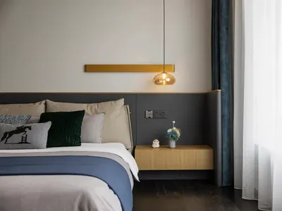 Modern bedroom featuring a bed with fabric and wood elements and a glass pendant light hanging above.