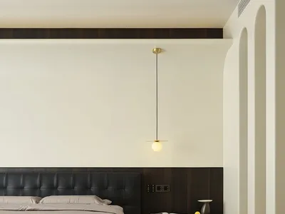 Modern minimalist bedroom featuring a black upholstered bed against a white wall and wooden floor.