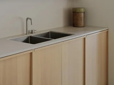 A modern, minimalist kitchen featuring a concrete countertop and cabinet.