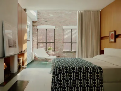 A minimalist bedroom with brick walls, white flooring, and a wooden headboard.