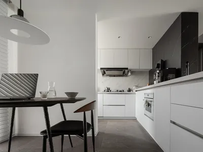 A modern kitchen with minimalist design, featuring marble countertops and stainless steel appliances.