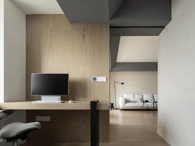 Modern minimalist home office with a wooden desk, white walls, and a sleek design.