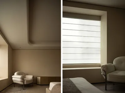 A minimalist bedroom featuring a bed with a white mattress and a cream-colored blanket, blinds in the window, and a white arm