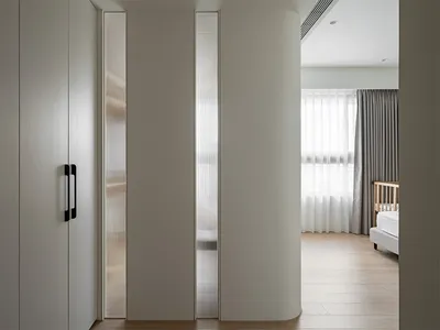 現代簡約臥室，配有白色櫃體、玻璃門板與木地板。