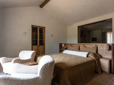 A minimalist bedroom with a wooden bed and fabric bedding.