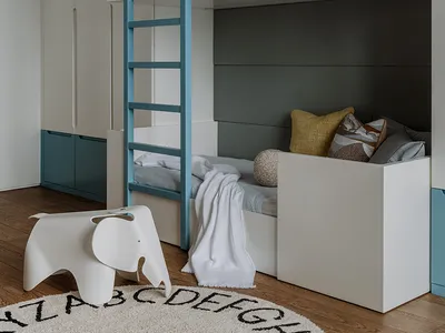 A modern minimalist bedroom featuring a bunk bed with teal accents and a wooden floor with an alphabet rug.
