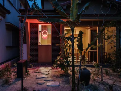 夜晚餐廳外觀，紅磚牆與混凝土結構搭配燈光照明。