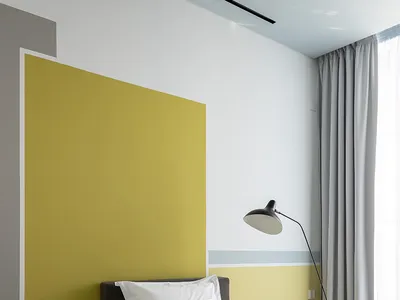 A modern minimalist bedroom with grey and yellow accents, featuring a grey bed with yellow and grey bedding, grey curtains, a