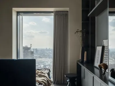 Minimalist bedroom with wooden bed, leather furniture, and industrial touches