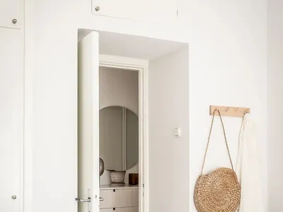 A cozy, minimalist bedroom featuring a woven basket, wooden furniture, and textured bedding.