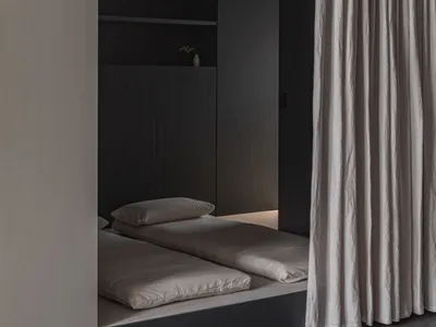 A minimalist bedroom with neutral tones and a simple, modern design.