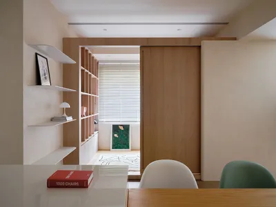 A modern home office featuring wooden shelves and a sliding door.