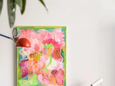 A vibrant abstract painting on a white wall above a dining room table with black chairs.