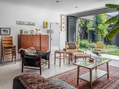 An industrial-style living room with a wooden coffee table and a patterned rug.