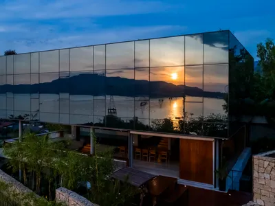 現代住宅酒店玻璃外牆映照日落景色。