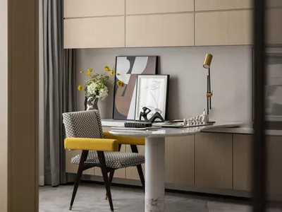 A modern home office featuring mixed materials, including a yellow chair, marble desk, and abstract art.