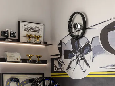 A minimalist bedroom featuring a concrete floor and decorative wall art depicting wheels and car parts.