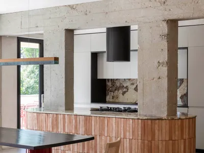 A modern minimalist kitchen featuring a wooden kitchen island and pendant lighting.
