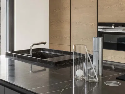 Modern kitchen interior featuring a sleek marble countertop and minimalist design.