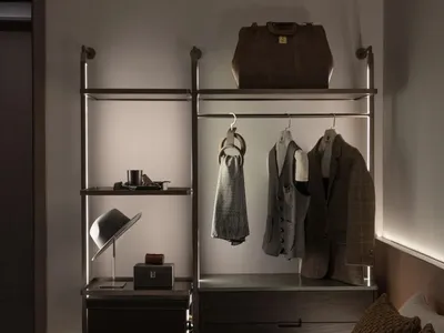 現代臥室內的金屬收納單元，衣物、帽子與其他物品整齊排列。