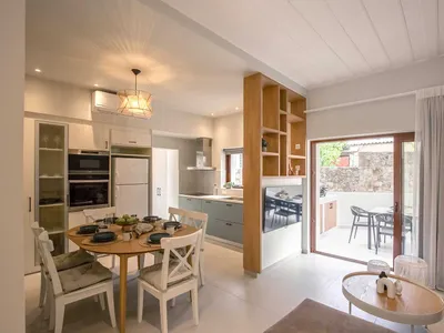 Modern minimalist kitchen with concrete countertops, wood composite flooring, and white cabinets.