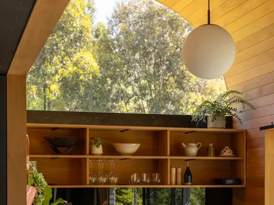 Modernly designed kitchen with open-plan floor layout, featuring dark wooden flooring and modern fixtures.