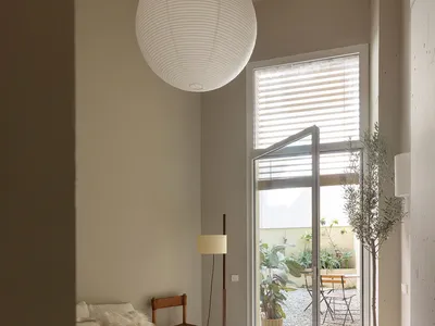 Bedroom with minimalist design, concrete floor, and white bedding.