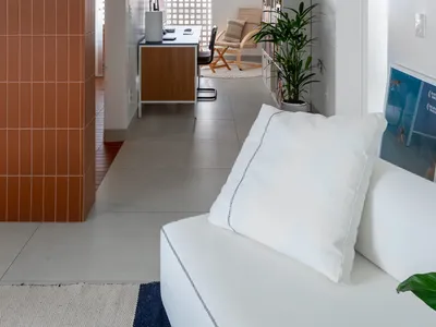 A modern home office with a tile accent wall and concrete floor.