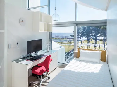 Modern bedroom featuring a window with a view of a landscape and a single bed.