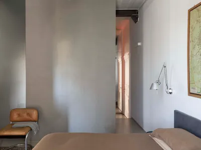現代臥室搭配金屬壁燈，極簡風格，混凝土地板。