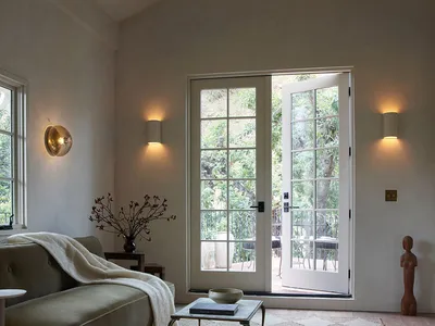 A minimalist living room with a metal coffee table on a white and beige floor, featuring a road-themed design and a view of t