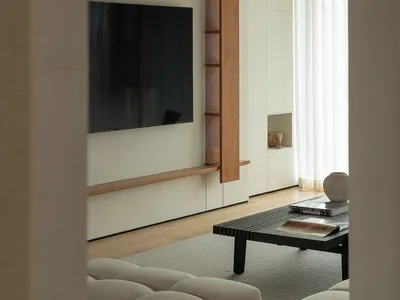 Modern industrial living room with minimalist design, wood furniture, and concrete walls.