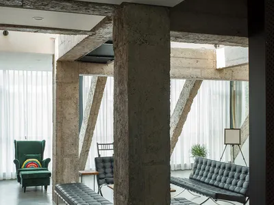 Modern industrial office lounge featuring concrete elements and minimalist furniture.