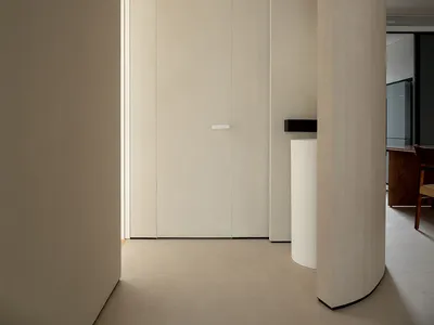 A minimalist kitchen with white walls, floor, and doors.