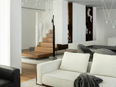 Modern minimalist living room with white couch, black armchair, and wooden accents.