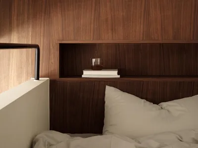 A modern minimalist bedroom featuring a wooden storage unit with books and a glass