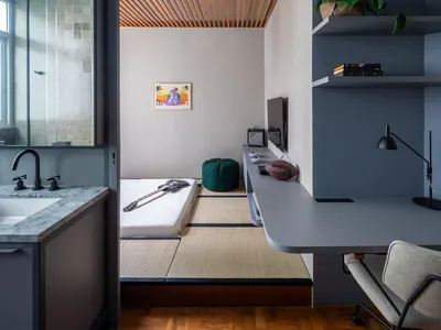 A minimalist bedroom featuring wood paneling, glass windows, and a tatami floor.