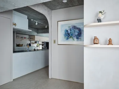 Modern kitchen with minimalist design, concrete countertops, and concrete walls.