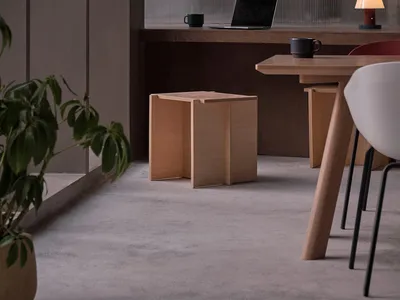 A modern home office space featuring minimalist design with wooden furniture and a laptop on a desk.
