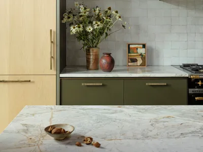 Modern kitchen featuring minimalist design, marble countertops, and green cabinets.