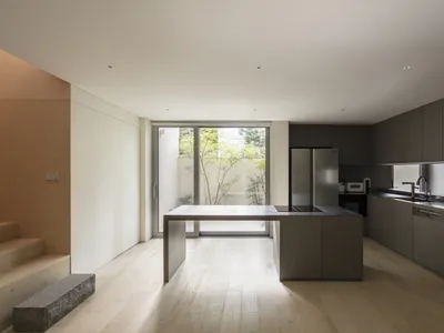 Modern kitchen with wooden flooring and minimalist design features.