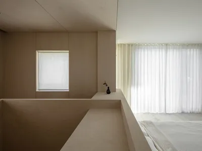 A minimalist bedroom with wooden walls, fabric curtains, and a simple bed setup.