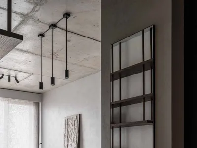 Modern minimalist kitchen with concrete and wood finishes, featuring a central island and minimalist design elements.