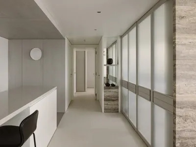 A modern minimalist kitchen featuring white materials, with an open layout and a sleek, minimalistic design.