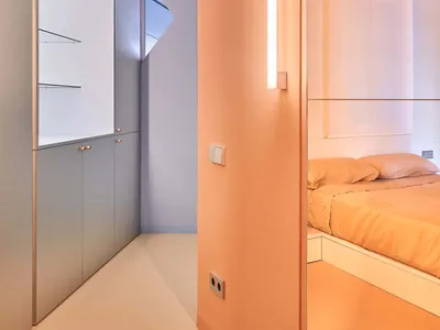 Modern minimalist bedroom with orange walls and white furniture, white floor