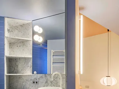 Modern minimalist bathroom with blue marble walls and white porcelain sink.