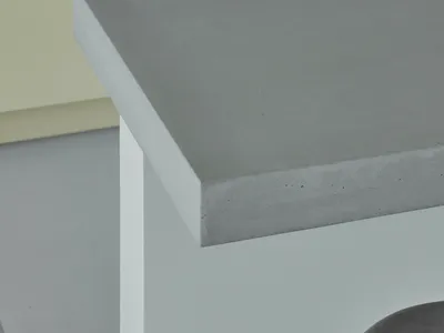 現代極簡風格的廚房，搭配灰色混凝土檯面與俐落白色櫥櫃。